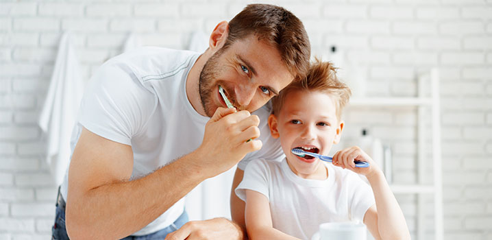 Vater und Sohn putzen gemeinsam Zähne