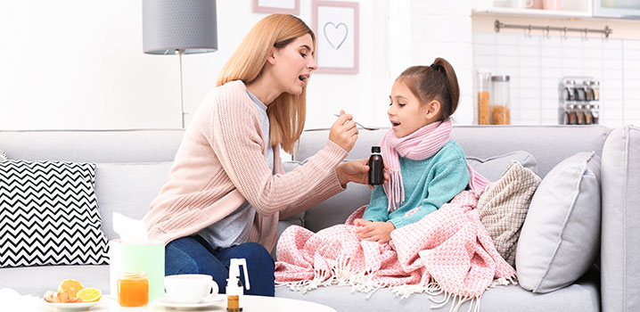 Mutter gibt erkälteter Tochter Hustensaft
