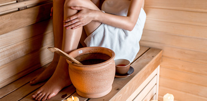 Frau sitzt auf Saunabank