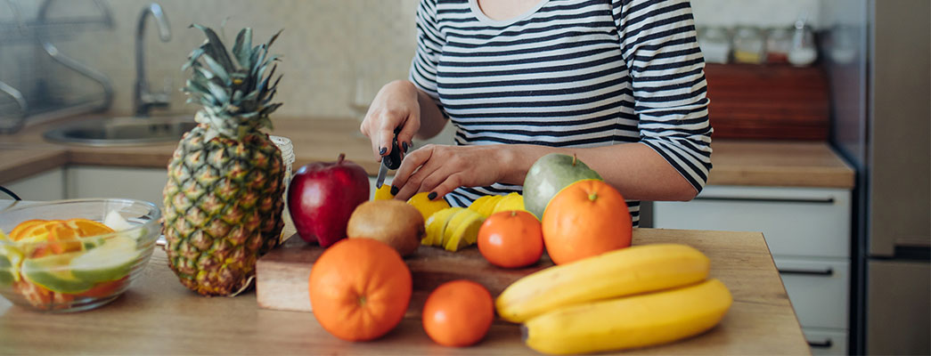 Frau schneidet vitaminreiches Obst