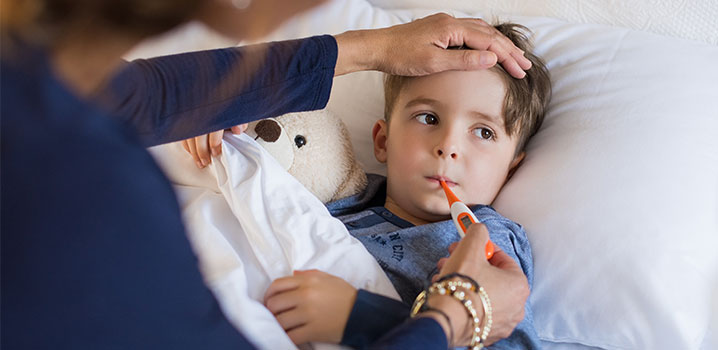 Krankes Kind mit Fieber im Bett
