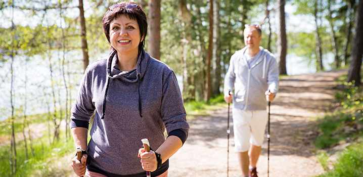 Mann und Frau beim Nordic Walking in der Natur