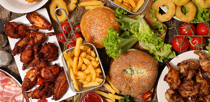 Tisch mit Hamburgern, Pommes, Chicken Nuggets und anderen frittierten Speisen