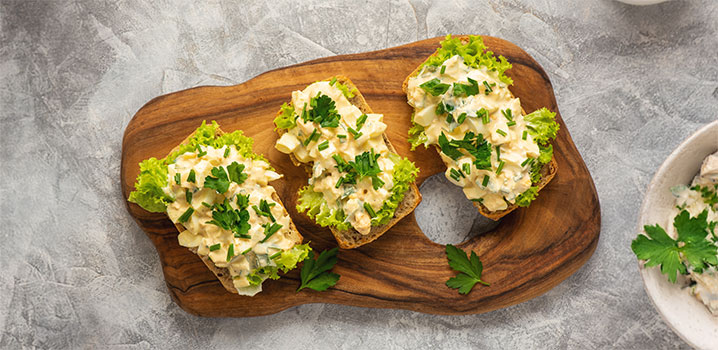 Mit Eiersalat bestrichene Brote auf einem Brett