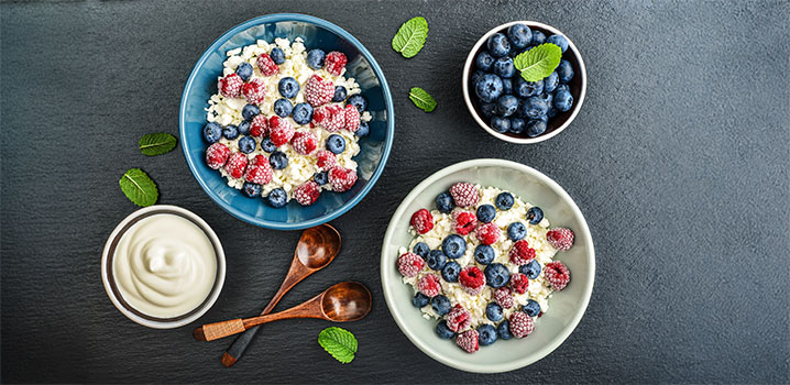 Schüsseln mit Hüttenkäse und frischen Beeren