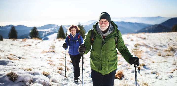 Älteres Ehepaar geht im Winter mit Walkingstöcken spazieren