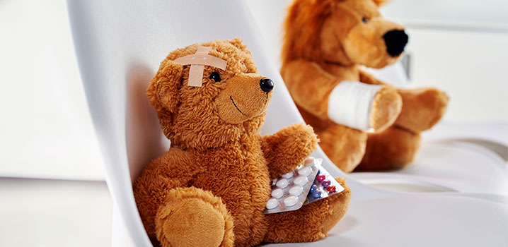 Ein Teddy mit Pflaster sitzt auf einem Stuhl