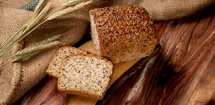 Kastenbrot mit Körnern auf Holztisch und Jutesack