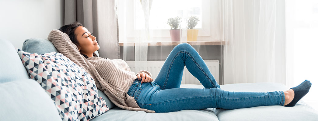 Frau entspannt sich ausgestreckt auf dem Sofa