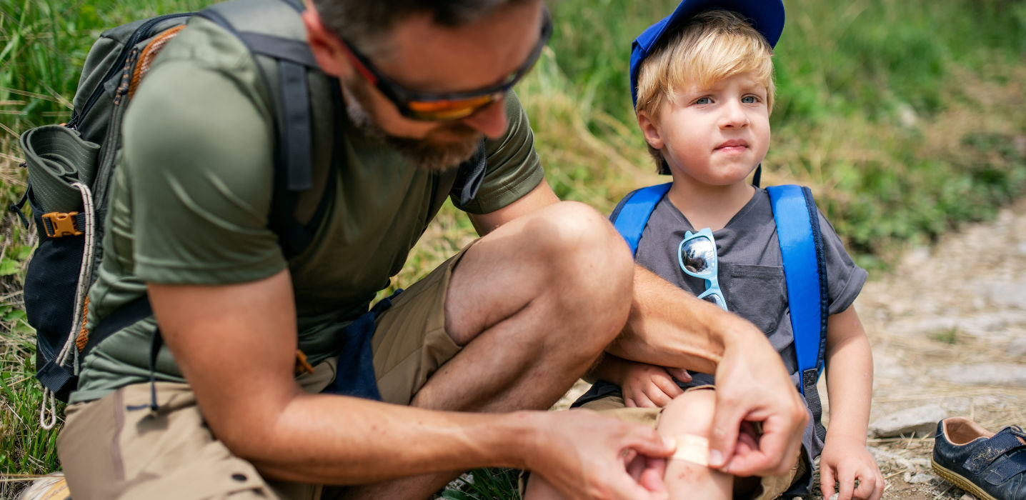 Vater versorgt seinen Sohn mit einem Pflaster