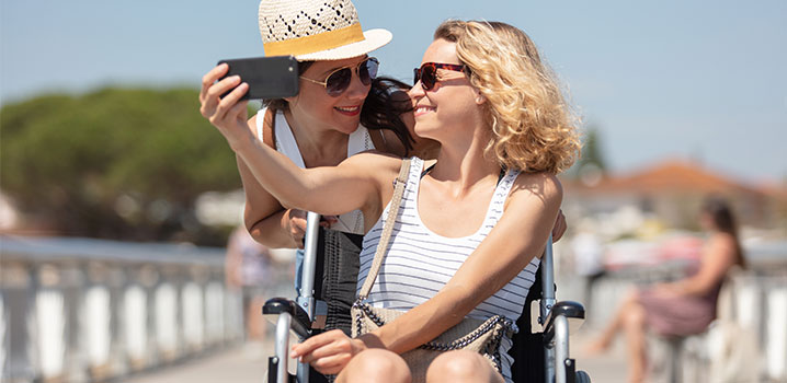 Eine Frau im Rollstuhl zusammen mit einer Freundin