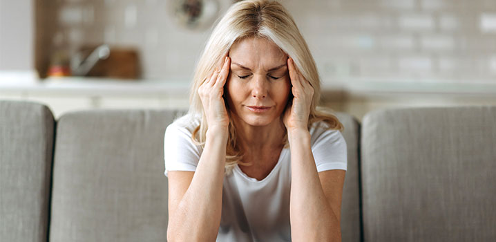 Frau die sich die Schläfen hält